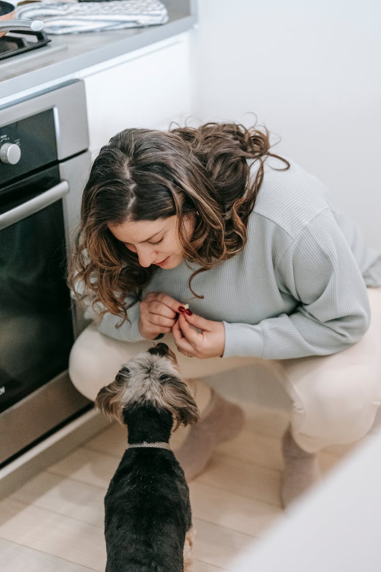 Woman With Dog In Kitchen