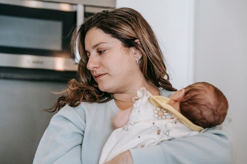 Mother with newborn baby in modern kitchen