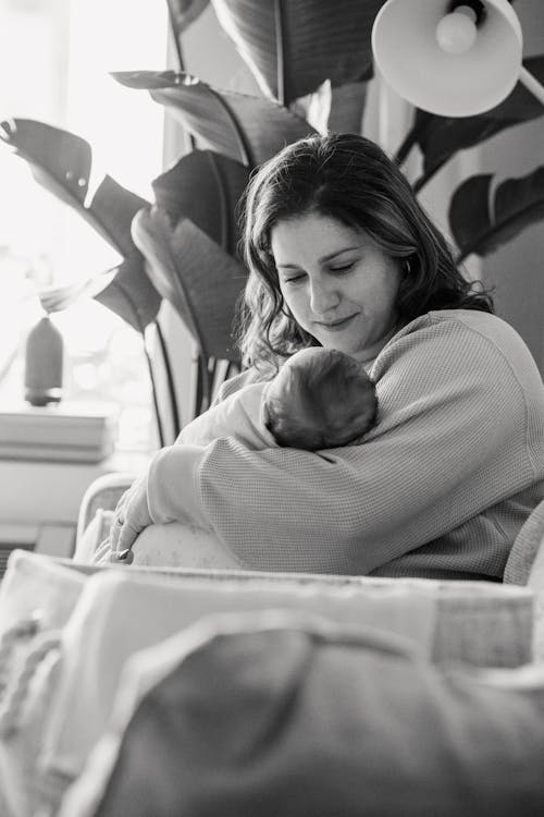 Mother with infant baby near basket at home