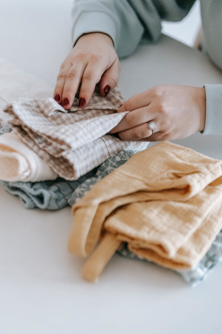 Person Wearing Long Sleeves Folding Clothes