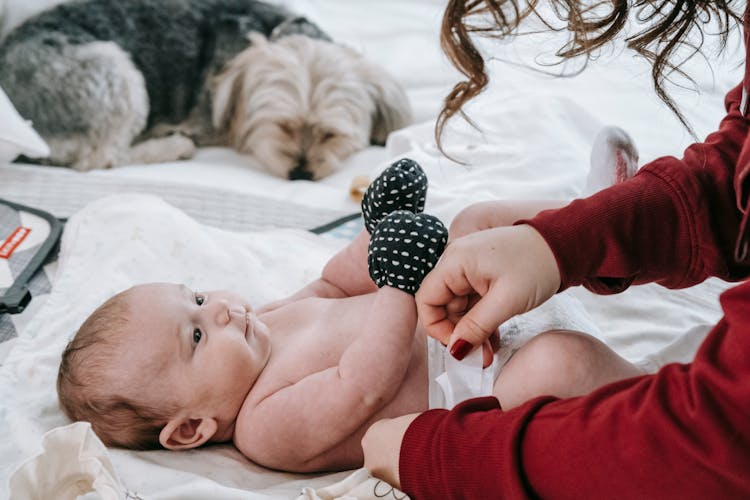 Faceless Mother Changing Diaper For Newborn Baby