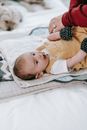 Faceless woman dressing baby on couch