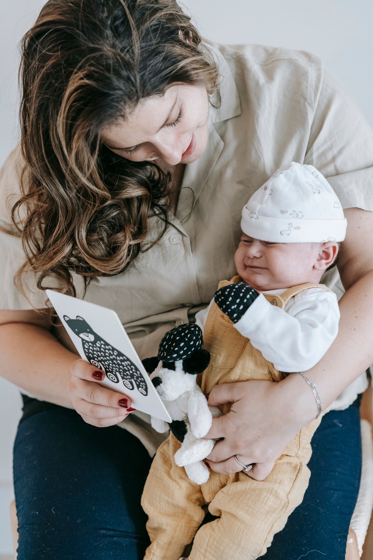 Mom reading a picture book to the newborn in her arms