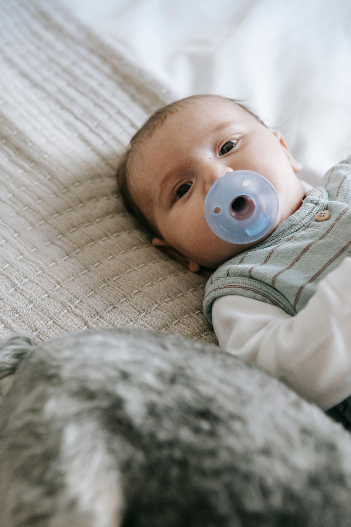 Baby with a pacifier for a pacifier hunt game
