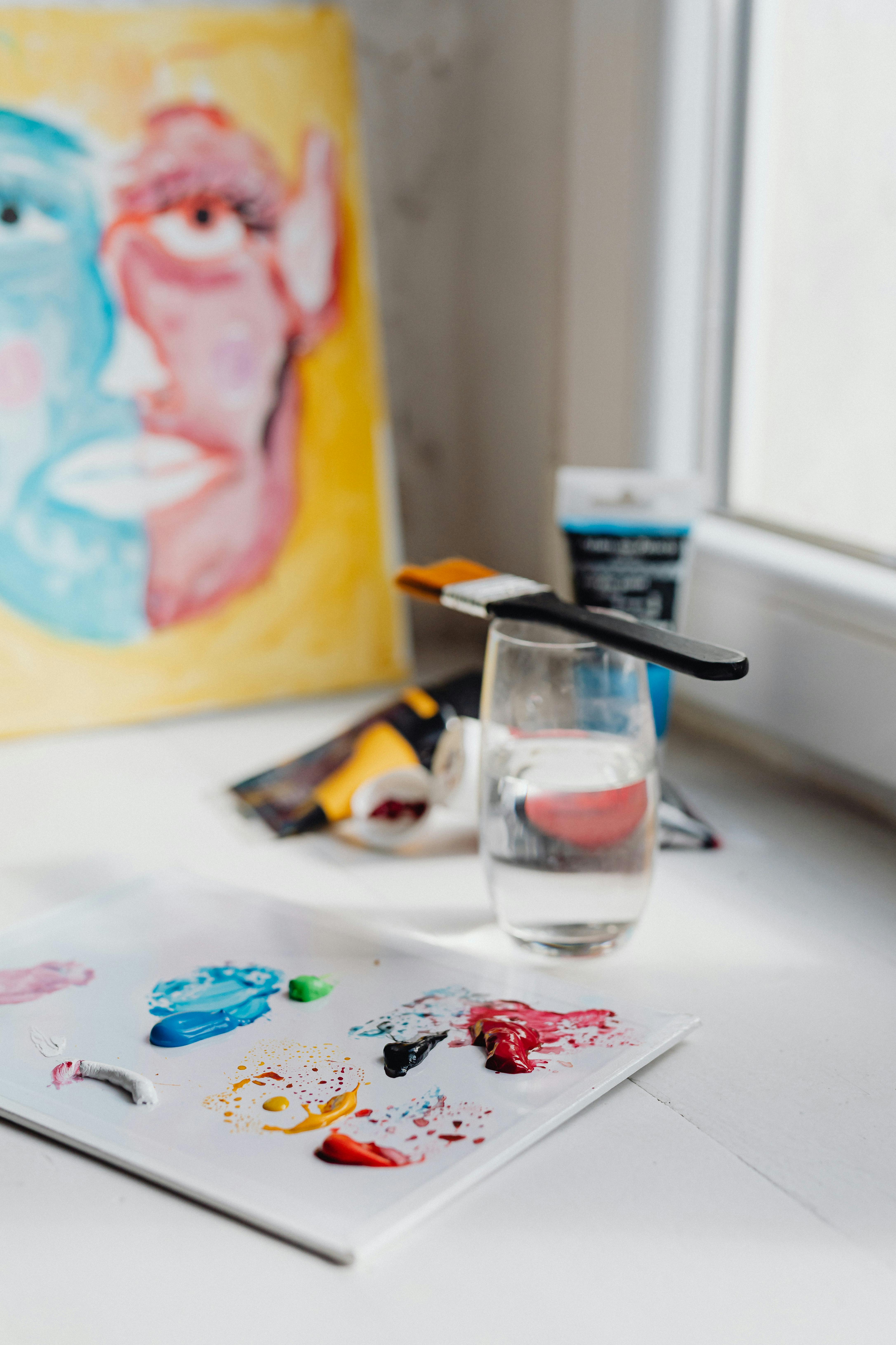 Photograph of Paint Near a Glass of Water