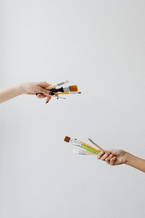 Hands with Drawing Tools on White Studio Background