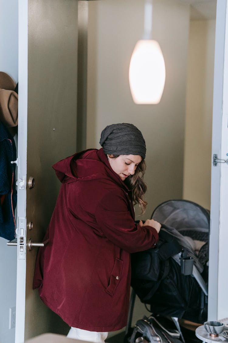 Woman With Baby Carriage Leaving Apartment