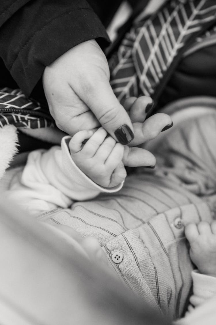 Baby Sleeping In Bed And Holding Hand