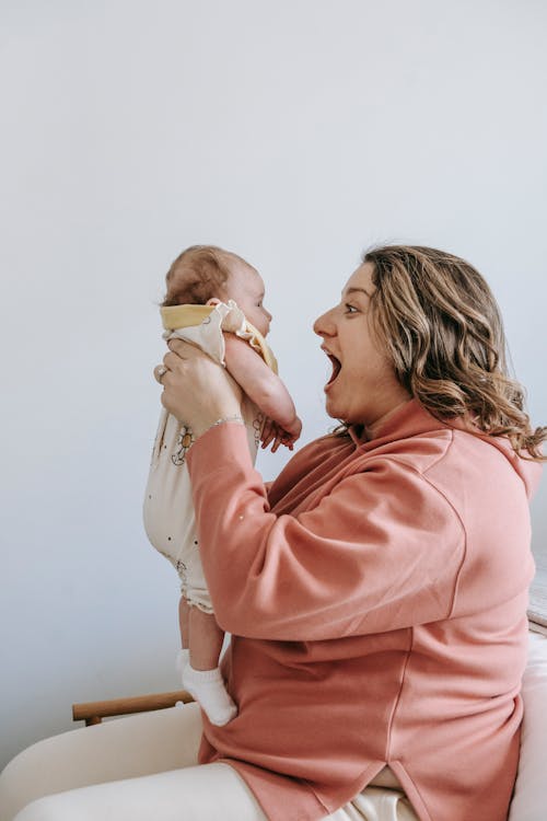 Amazed mother with infant baby in arms