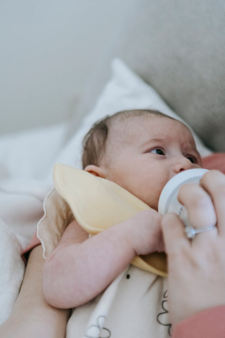 Faceless Mother Feeding Newborn Baby