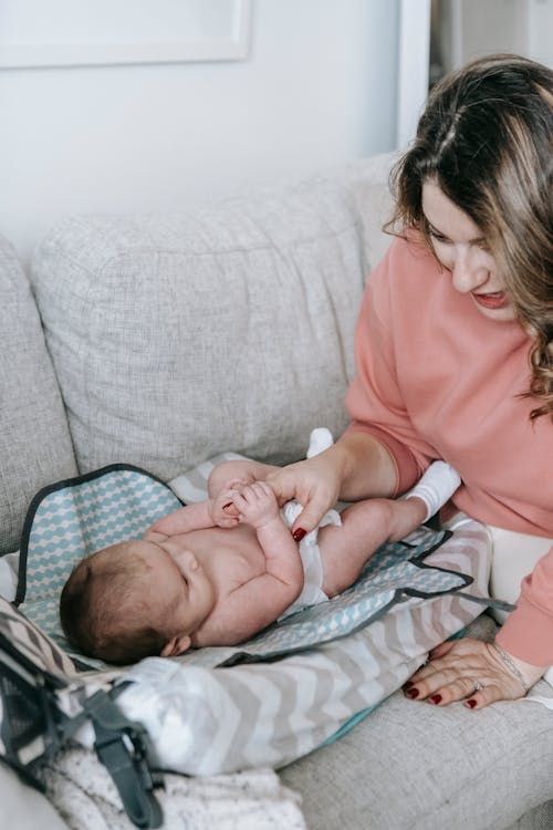 Mother with newborn baby on couch