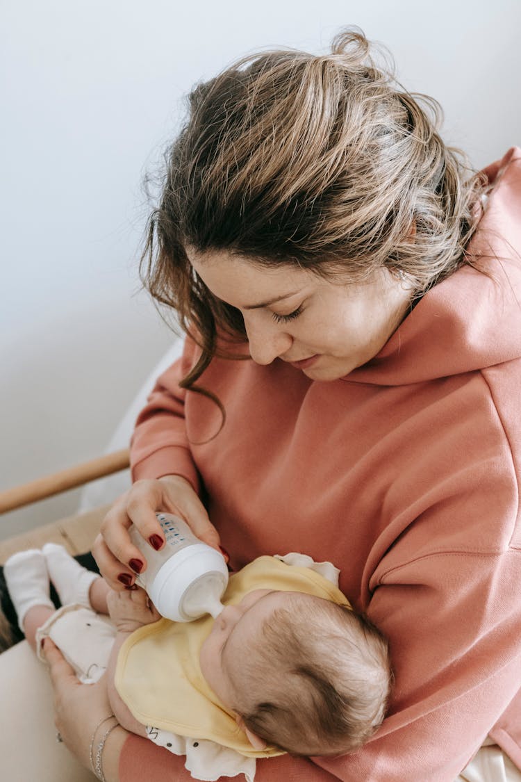 Mother Feeding Newborn Baby With Bottle