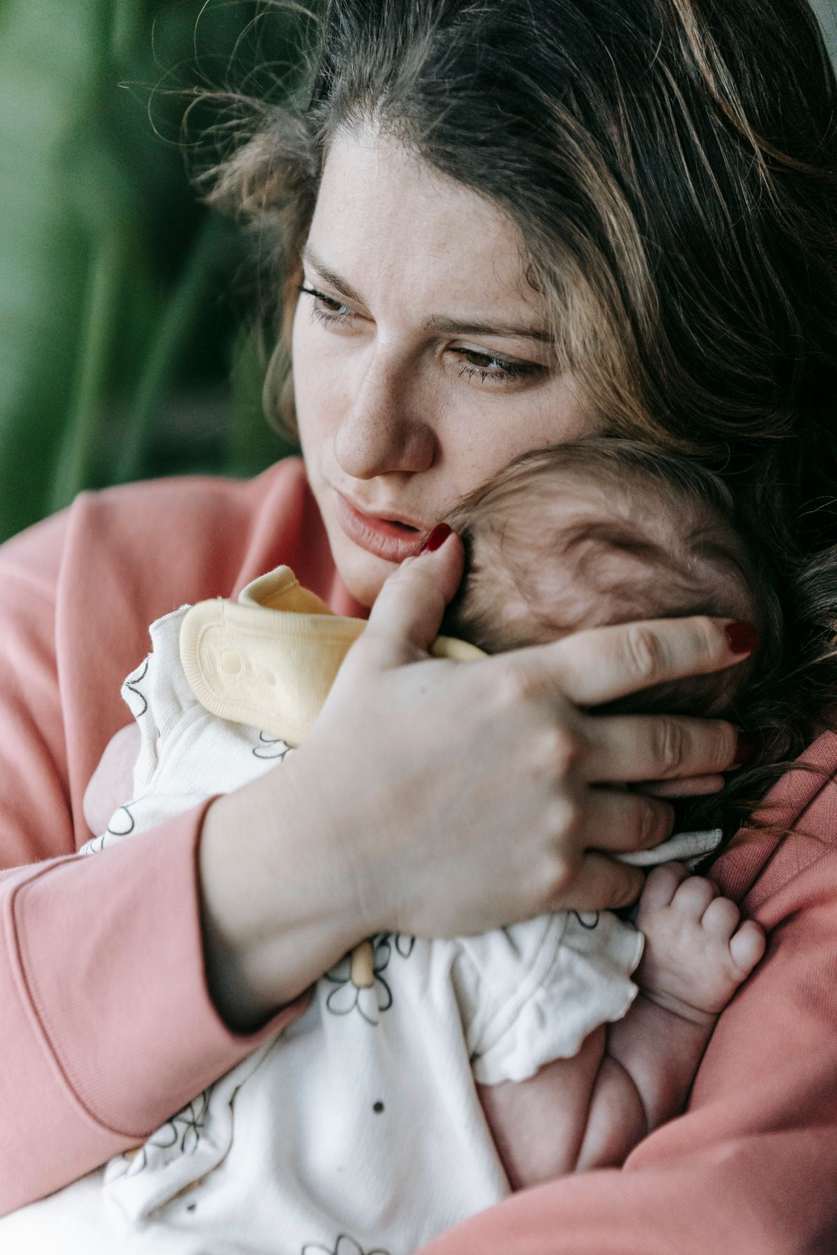 Mother gently holding and comforting her infant baby in her arms