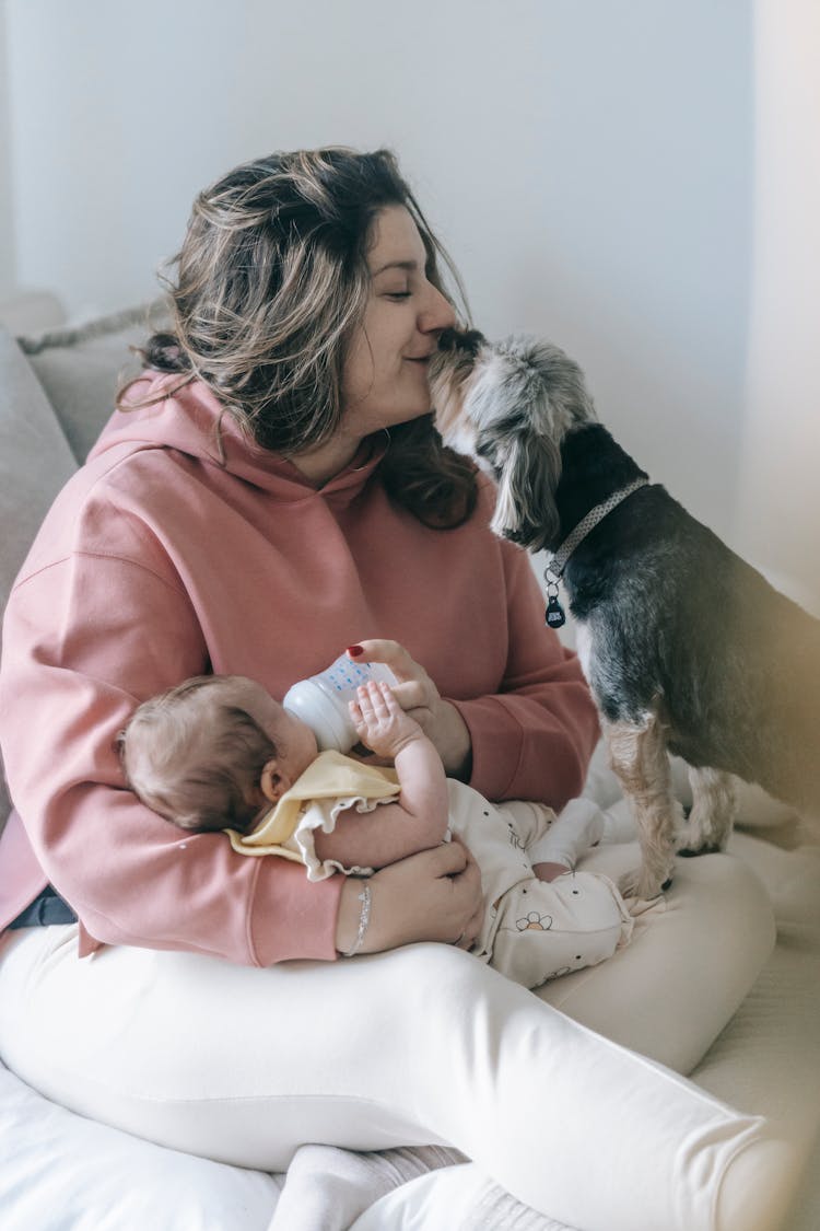 Content Mother Caressing Dog While Feeding Baby