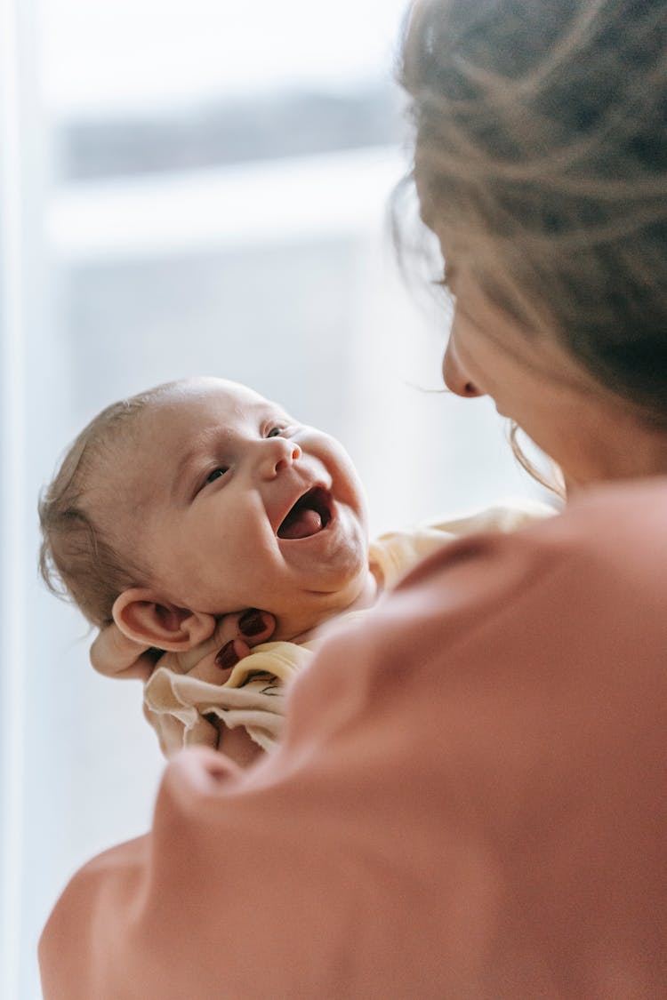 A Mother Carrying Her Smiling Baby