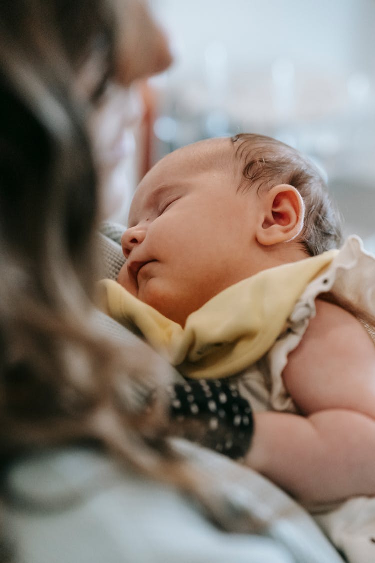 Cute Baby Sleeping In Hands Of Crop Mother