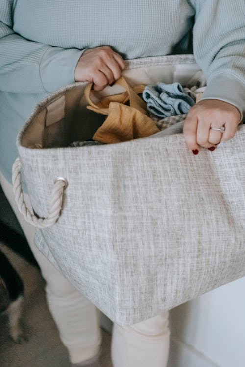 Free Crop faceless woman with laundry bag in hands Stock Photo