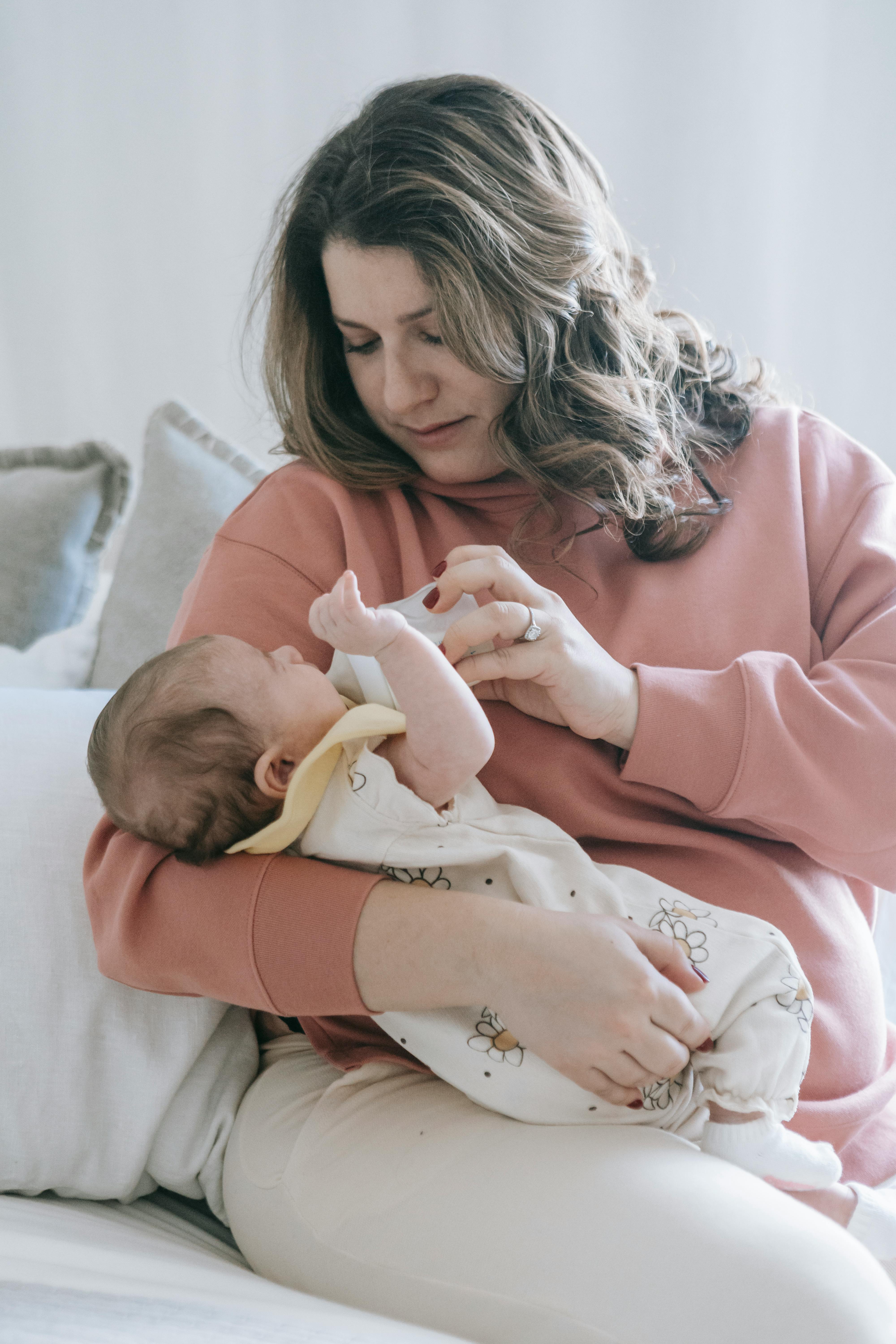 A mother lovingly cradles her newborn, capturing a tender and intimate moment.