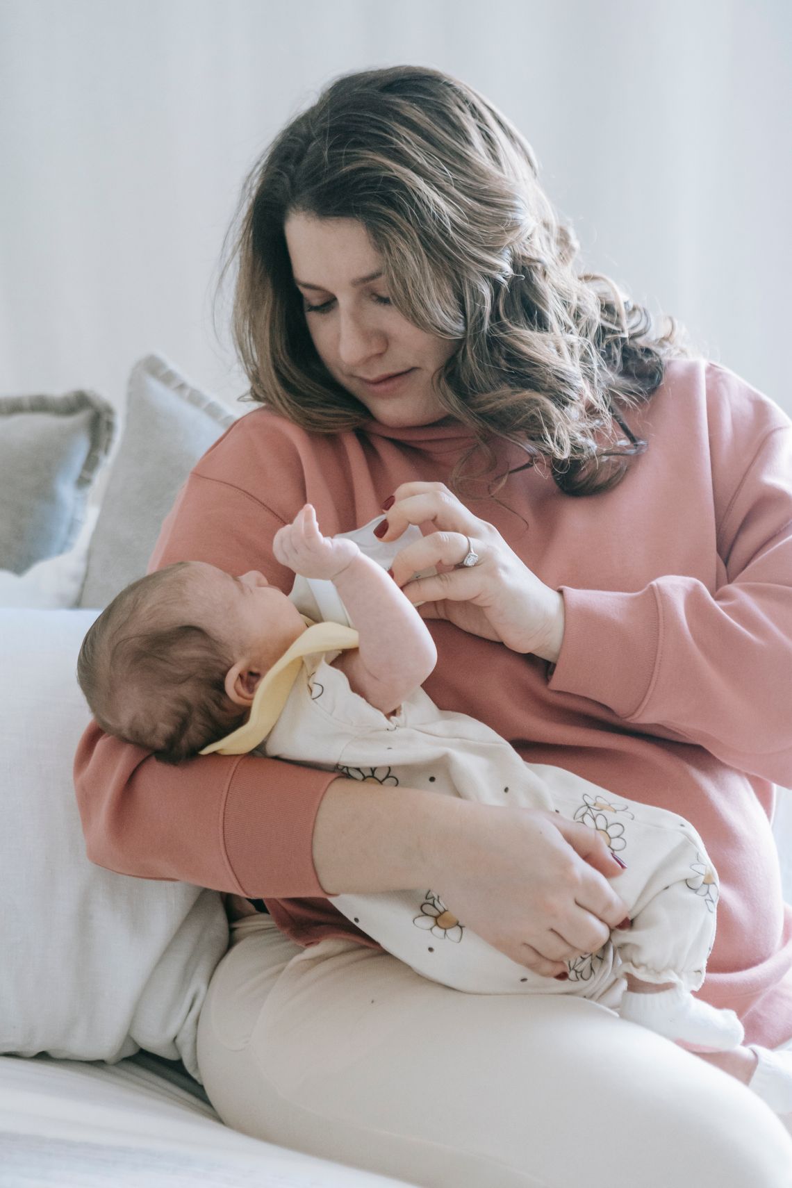 Mother caring for and feeding her baby at home