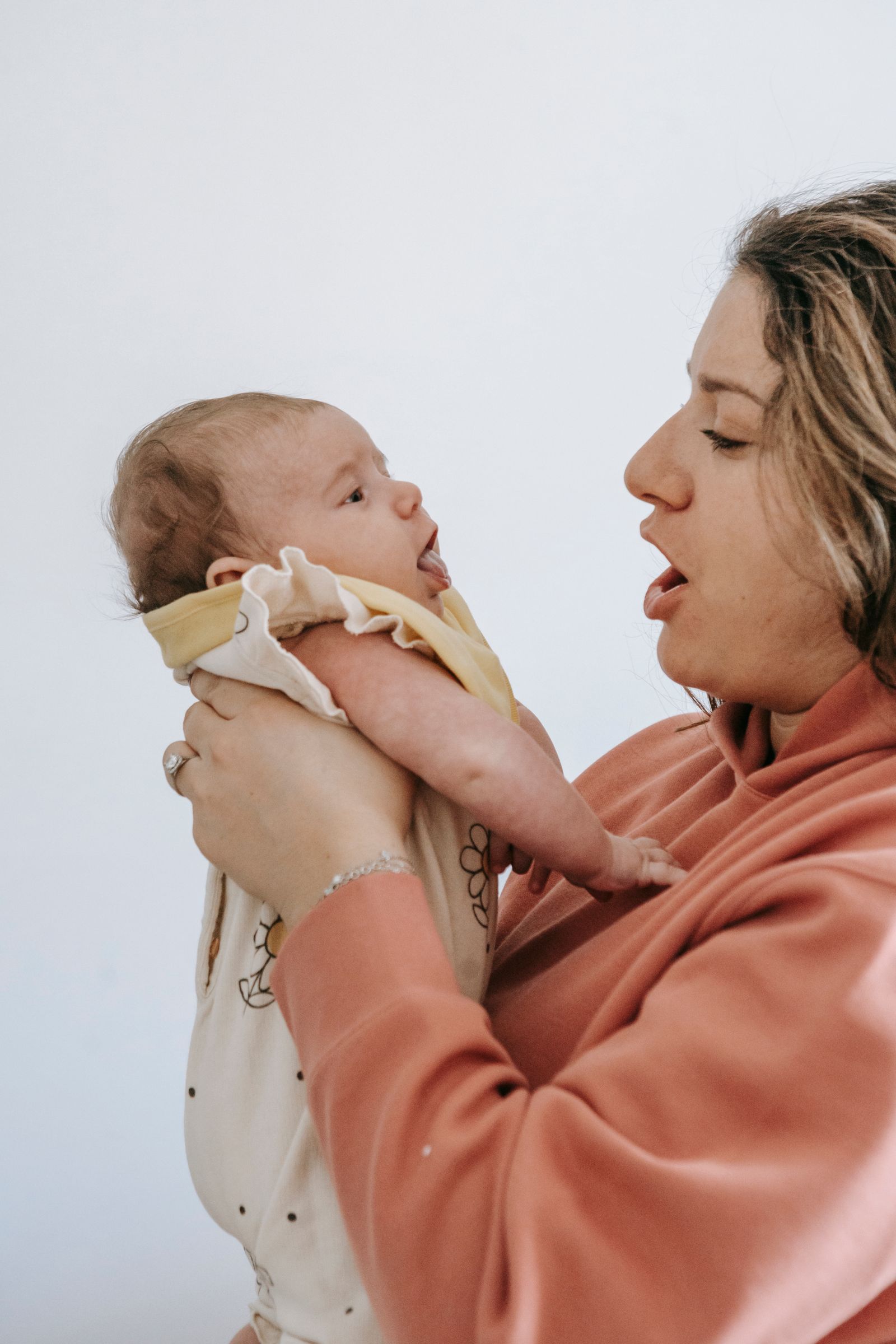 Parent holding a baby with visible hands and wrist positioning during infant care. Photo: Pexels.