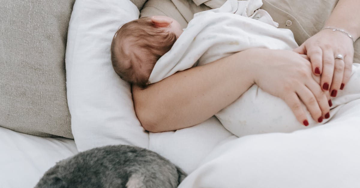 Young mom with cute baby and dog sleeping on bed