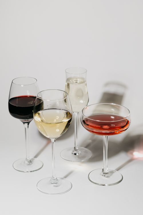 Free An elegant still life of various wine glasses showcasing different types of wines on a minimalist surface. Stock Photo