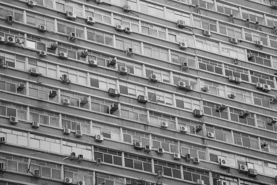 Nowoczesny balkon z jednostką klimatyzatora na szarej elewacji