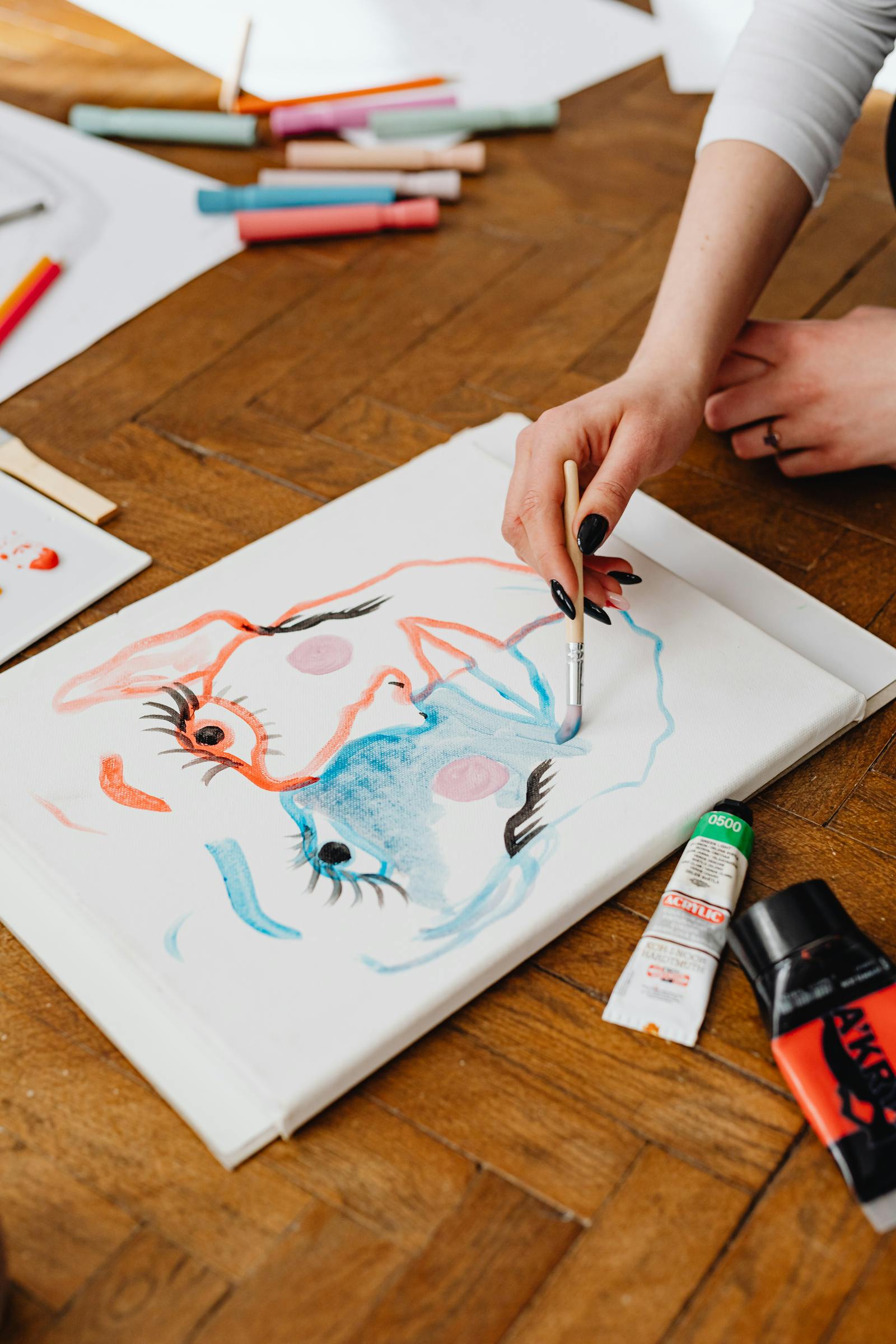 Primo piano di una mano che dipinge su carta con pennello