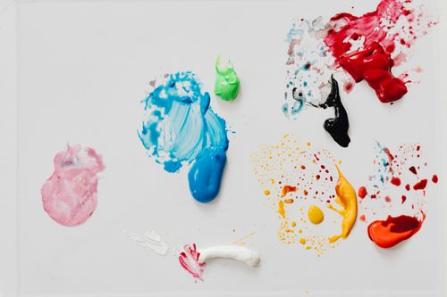 Free Colorful paint splatter in various hues on a white background, creating an abstract design. Stock Photo
