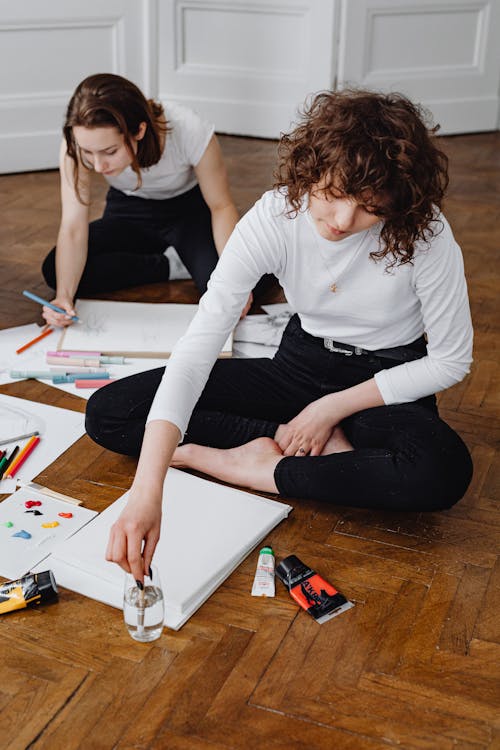 Women Sitting on the Floor while Doing Artworks