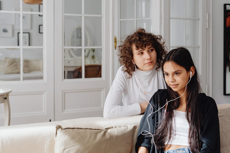 Women Listening To Music While Sitting On The Couch