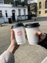 Crop couple clinking with coffee cups