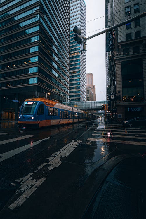 Free A Train Crossing on the Street Between Buildings Stock Photo