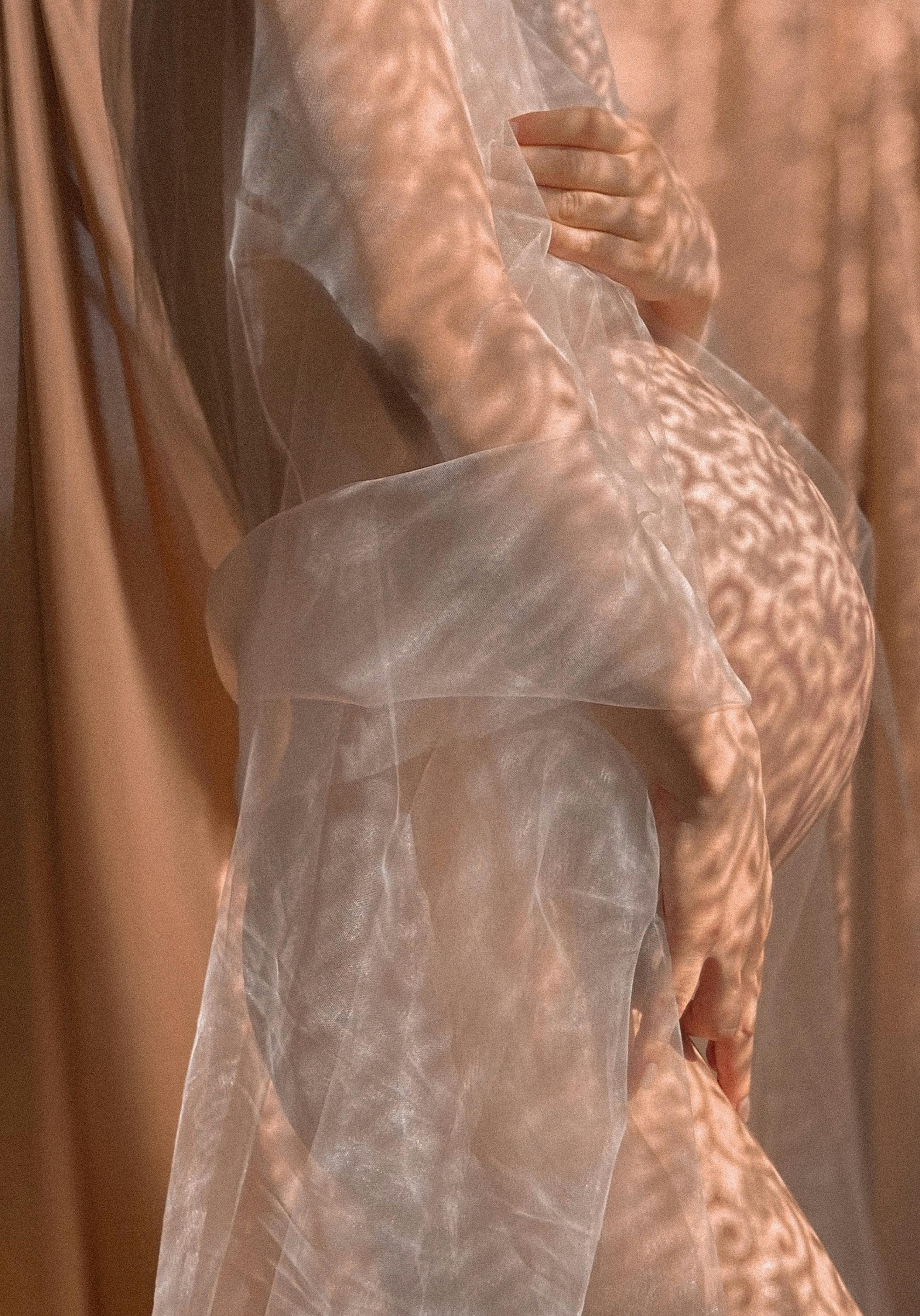 crop pregnant woman in transparent outfit