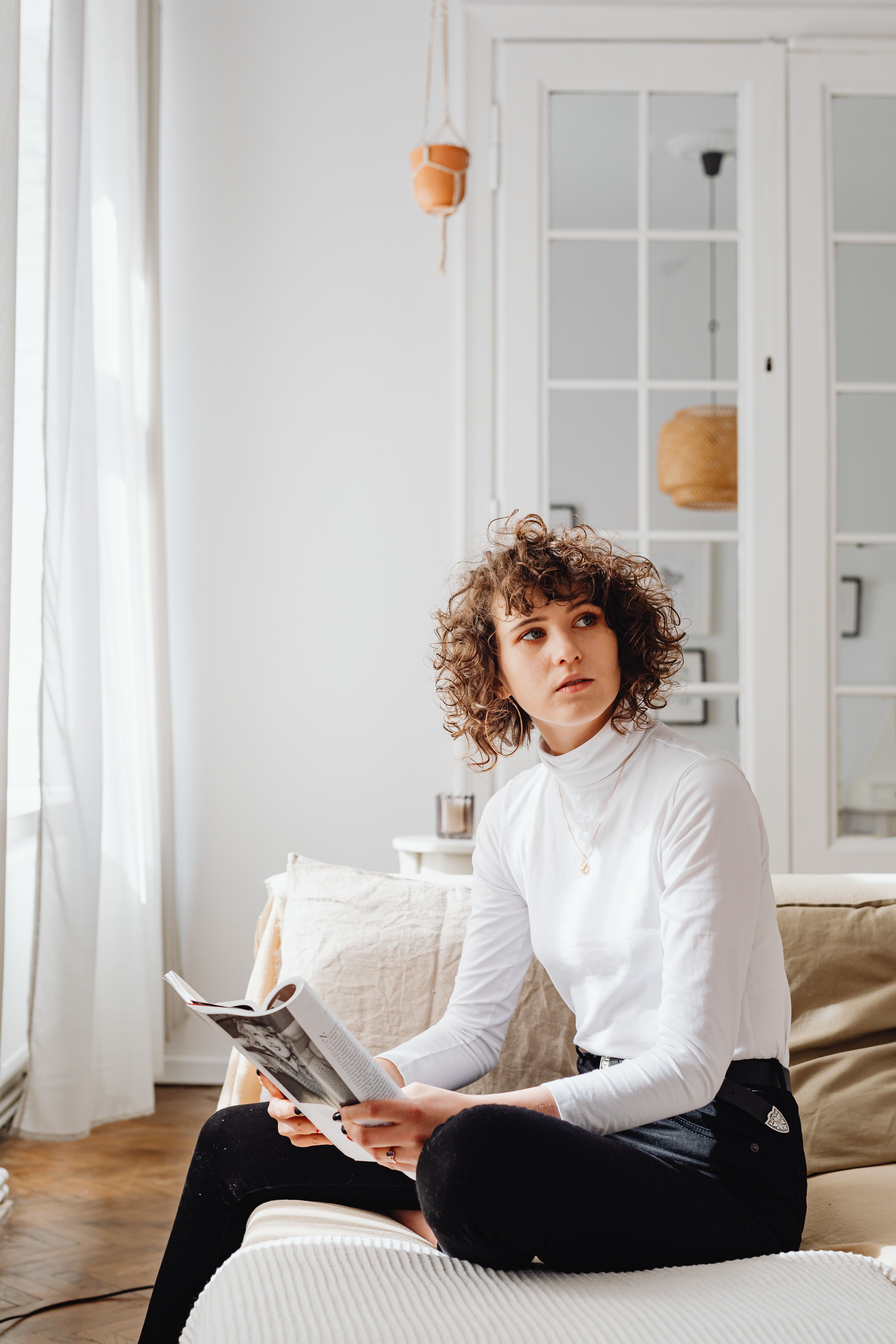 Woman in White Long Sleeve Shirt Sitting on a Sofa · Free Stock Photo