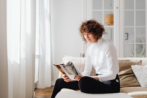 Woman in White Long Sleeve Shirt Reading a Book