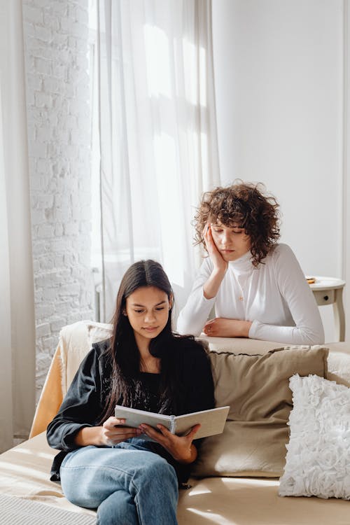 Free Women Reading a Book Together Stock Photo