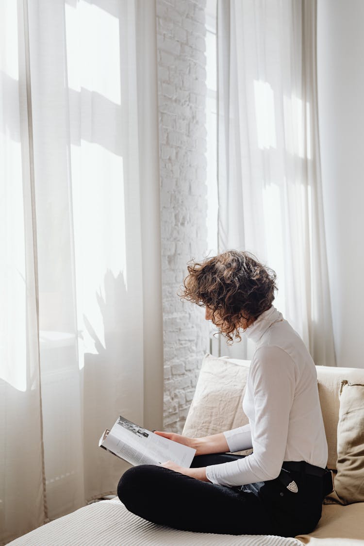 Woman In White Long Sleeve Shirt Reading A  Magazine