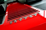 红色法拉利格栅的详细视图，带有金属字样，展示了现代汽车设计