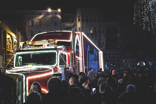 Les Gens Se Sont Rassemblés à Côté D'un Camion Coca Cola Pendant La Nuit