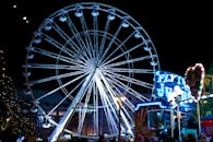 热闹的夜间狂欢节上，灯火通明的摩天轮和丰富多彩的景点格外引人注目