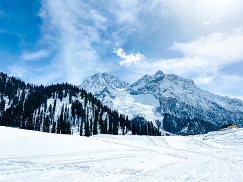Free Stunning snowy mountain landscape with clear blue sky and dense pine trees. Stock Photo