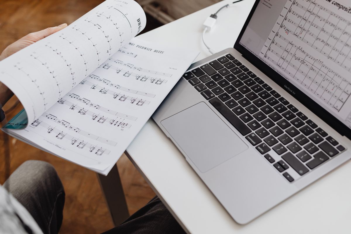 Close-up photo of study research book beside a laptop representing PDF paper organization for literature review.