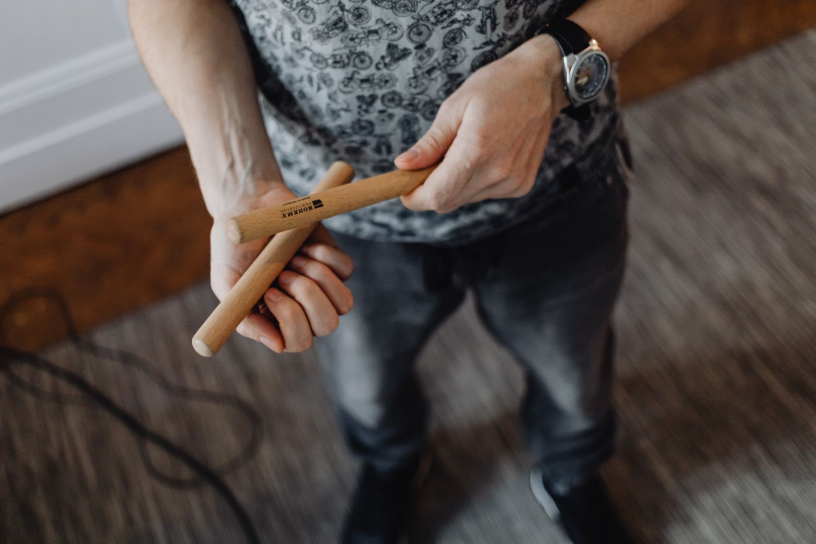 Close-up of a man's hands holding drumsticks, showing correct grip position