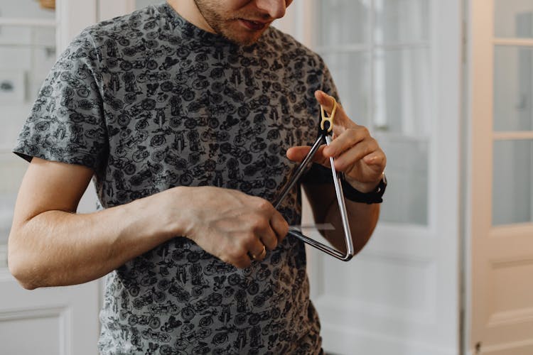 Close-Up Shot Of A Person Playing A Triangle Instrument