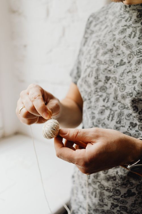 Free Hands delicately crafting with yarn in a well-lit indoor setting, showcasing artistic skill. Stock Photo