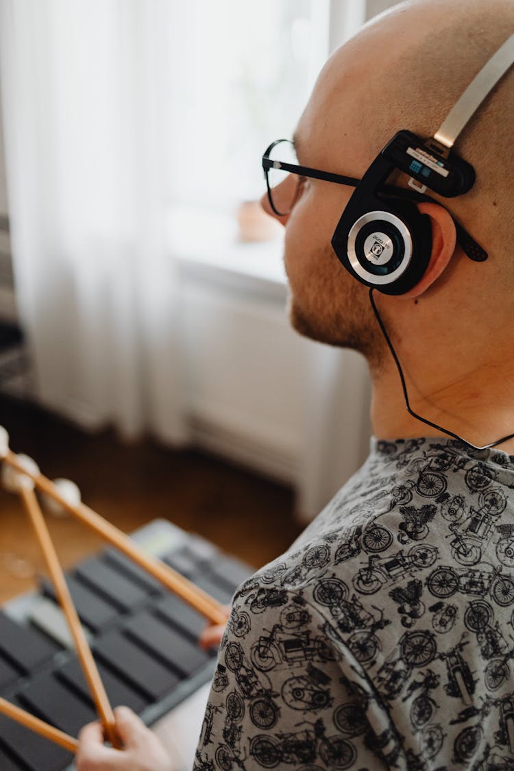 Man With Earphones Holding Drum Sticks