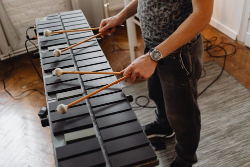 Free Musician using mallets to play an electronic xylophone in an indoor setting. Stock Photo
