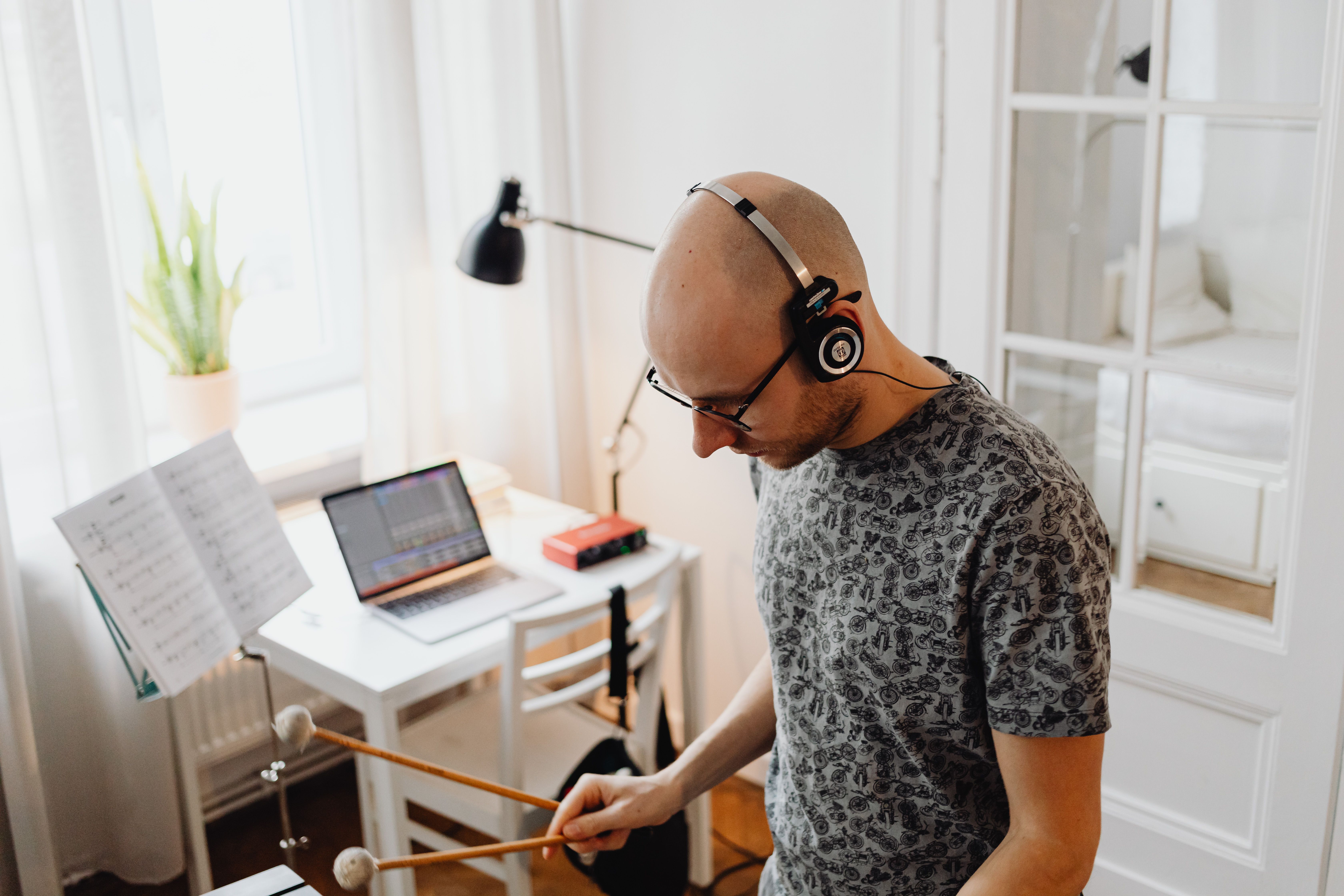 Gen Z musician recording music in messy bedroom with phone and laptop, DIY aesthetic