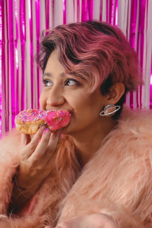 Woman in Fur Coat Eating Donut